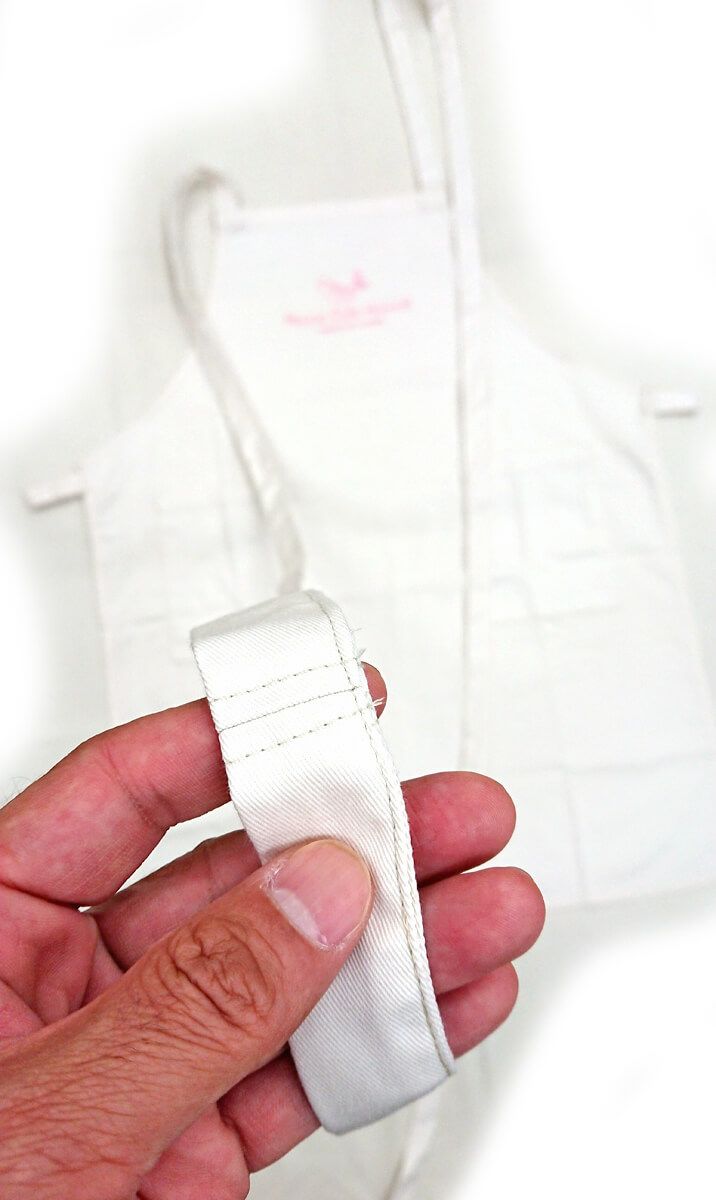 こうやってエプロンの腰紐を長くする事により後ろではなく前で結べるようにカスタムいたしました。