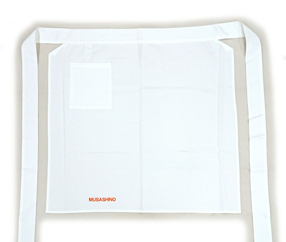 武蔵野栄養専門学校様に注文いただいた厨房エプロンにポケットを取り付けたお写真を紹介です。<br>綿100％の白エプロンはだいたいの場合、ポケットが付いていないものが多いです。<br>弊社でも取り扱い商品の中から探しましたが、やはりなかったので、ポケット取付加工をさせていただく事にいたしました！