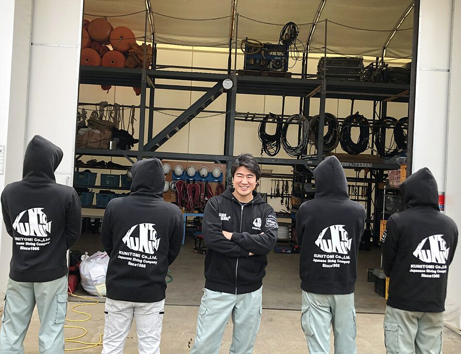 お次は背中のロゴマークも見せていただきましょう♪<br>魚のイラストの中のKUNITOMIのデザイン文字が素敵です。<br>やはり前後ともにお揃いのロゴ入りなので、見た目に統一感があって最高ですね♪