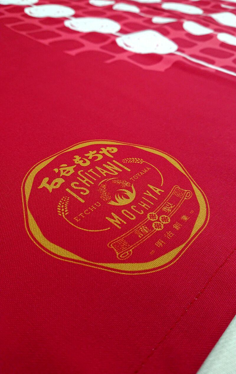 伝統を感じる石谷もちや様のロゴマーク部分の超拡大アップ写真です。<br>サッカーユニフォームを作る技術と一緒のフルカラー昇華転写プリントという方法でプリントしています。<br>弊社で作るオーダー暖簾（のれん）は、色落ちもしにくく、値段は高くなりますが、長持ちするのが良い所。