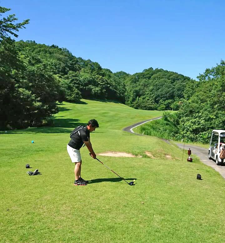 福知山東ゴルフのゴルフレッスンプロ山脇さんが水冷ベストを着用してドライバーショットしている写真です。