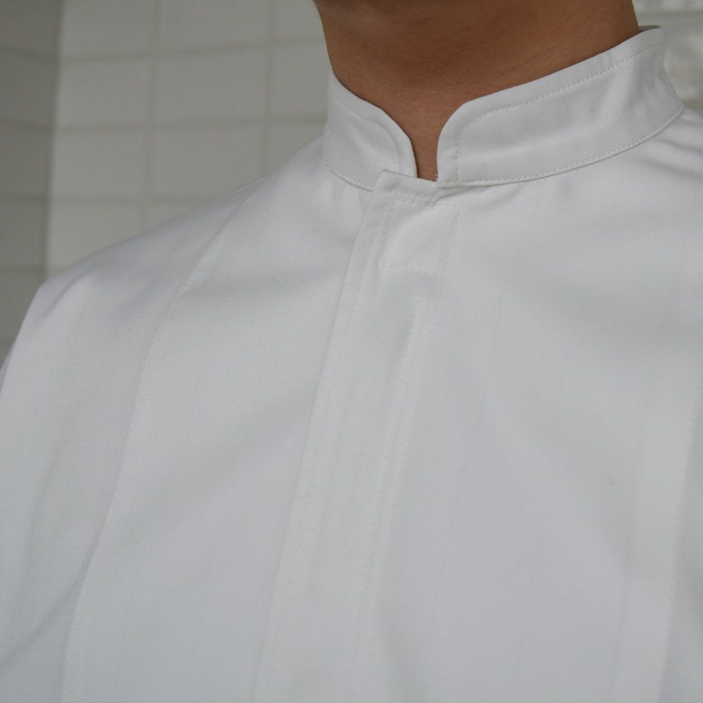 襟：首まわりを締め付けない、ゆったりめのスタンドカラー。頭巾の裾を中に入れれば、頭髪の落下を防止できます。落下を防止できます。