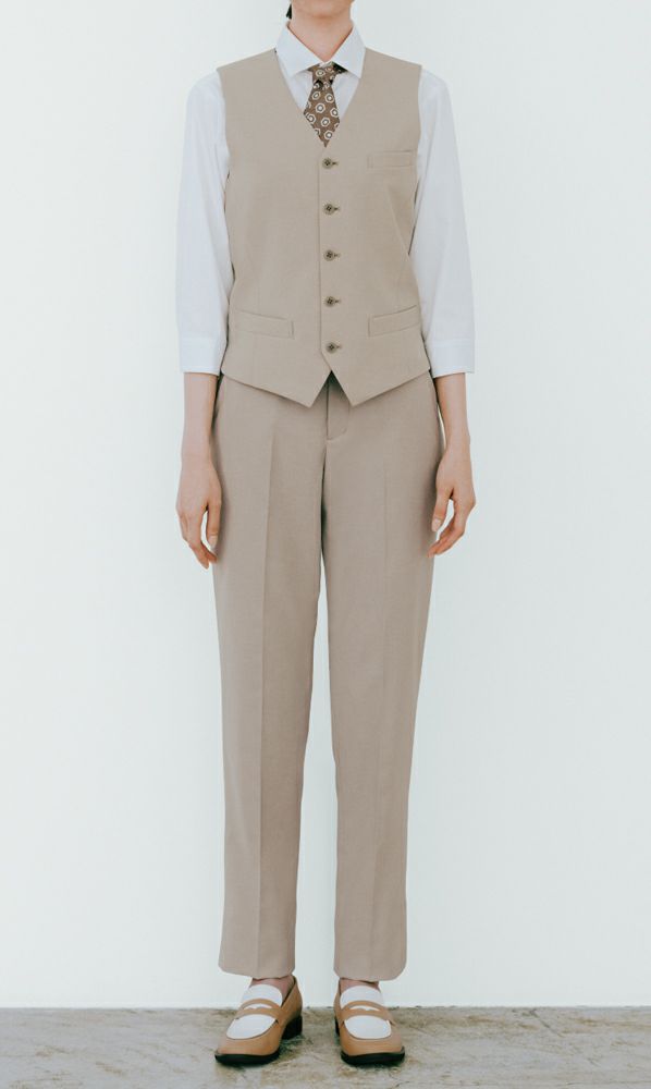 テーパードパンツとベストの好感スタイルにネクタイ風のスカーフで華やかに。凛々しい装いはフロントにも。